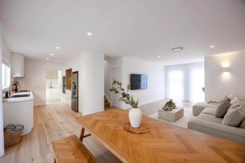 a living room with a vase on a wooden table at Olas Villa 4 - Plunge Pool & Walk to Beach in Anna Bay