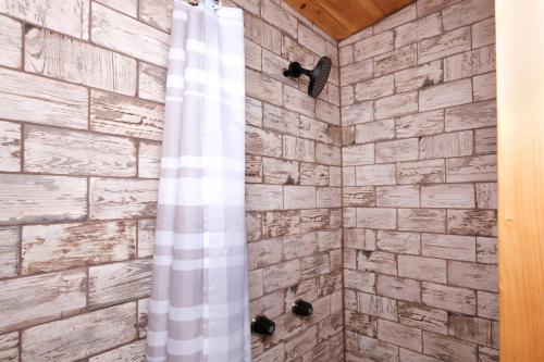 Un baño con ducha con pared de piedra. en Sleepy Bear, en Sevierville