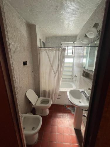 a bathroom with two sinks and a toilet and a tub at Punta Iglesia in Mar del Plata