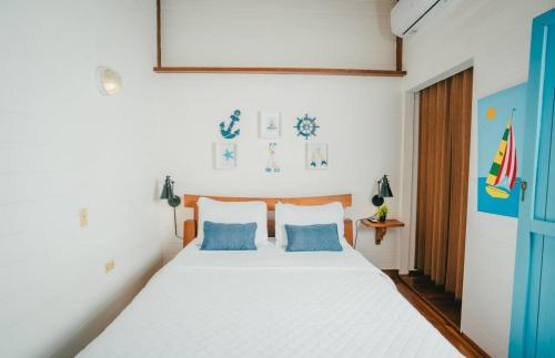 a bedroom with a white bed with blue pillows at AMAZING Bay View Marea 2-2 in Culebra