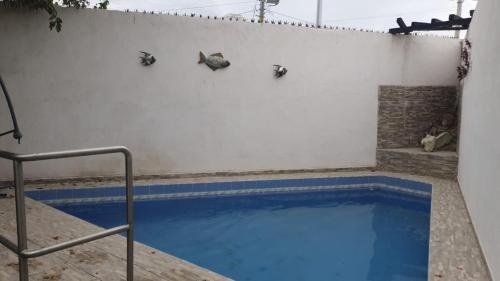 a swimming pool in a white wall with a blue water at Torreón 3 - Habitación cerca del aeropuerto con alberca in Torreón