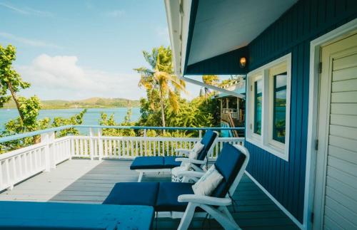 a porch with blue chairs and a view of the water at AMAZING Bay View Marea 2-2 in Culebra