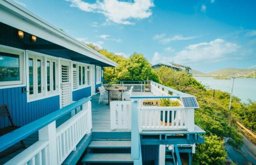 a blue house with a balcony with a view of the water at AMAZING Bay View Marea 2-2 in Culebra