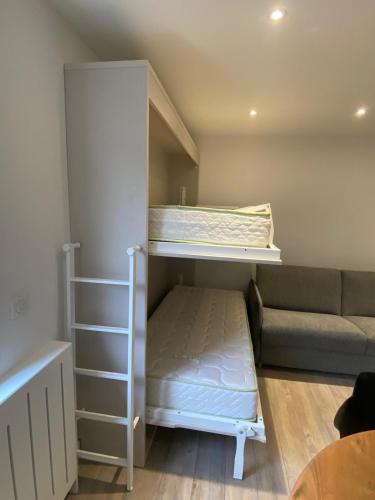 Cette petite chambre comprend des lits superposés et un canapé. dans l'établissement Croisette Palm Beach Studio, à Cannes