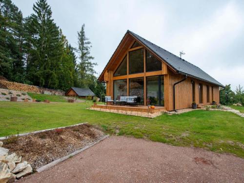 a large wooden house with a large window at Apartment near Pern tejn Castle in Smr ek in Ujčov