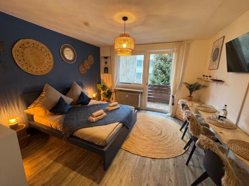 a bedroom with a bed and a table and a window at BOHO Apartment Zirbe Blue in Bad Reichenhall