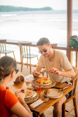 a man and woman sitting at a table eating food at Azuri Bay in Galle