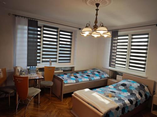 a bedroom with two beds and a table with chairs at Dom Lawendowy in Lubasz