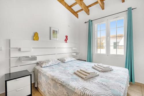 a bedroom with a bed with towels on it at Villa Forte in Cala'n Porter