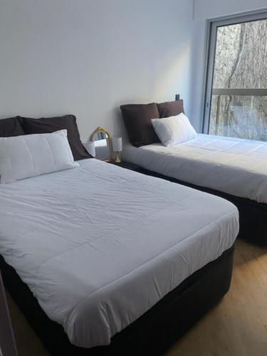 deux lits dans une chambre avec une fenêtre dans l'établissement Appartement Trocadéro, à Paris