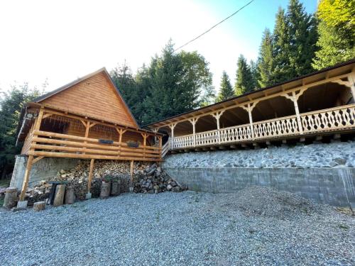 a wooden building with a bridge over a river at Hidden Valley in Muntele Cacovei