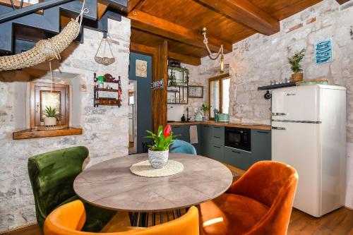 a kitchen with a table and chairs and a refrigerator at House Morski brk in Trogir