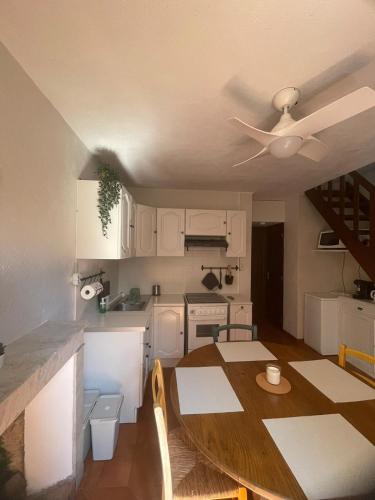 une cuisine avec une table et un ventilateur de plafond dans l'établissement Duplex au coeur du village, à Piana