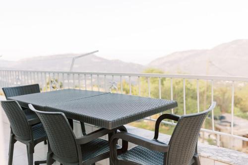 a black table and chairs on a balcony with mountains at Cozy Mountain View House Near Olympos & Adrasan in Kumluca