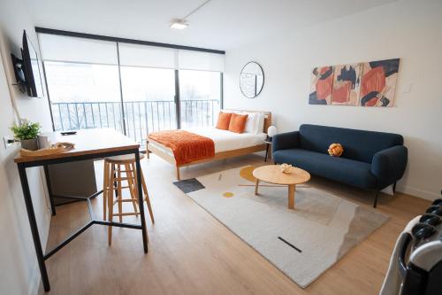 a living room with a blue couch and a bed at Salt City Getaway in Salt Lake City