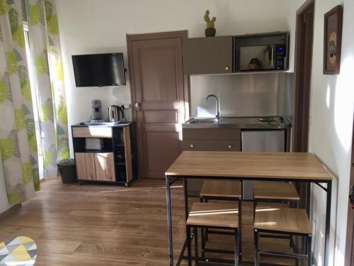 une cuisine avec une table et des chaises dans une pièce dans l'établissement Appartement T2 Centre, à Carpentras
