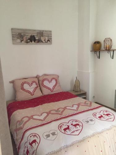 une chambre avec un lit avec des cœurs dessus dans l'établissement Appartement T2 Centre, à Carpentras