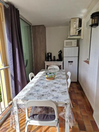 une cuisine avec une table et des chaises dans une pièce dans l'établissement Joli appartement pour 4 personnes situé a 300m de la plage, au Cap d'Agde