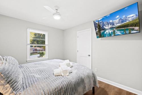 a bedroom with a bed and a tv on the wall at 2 bathroom, downtown Davidson - La Casita in Davidson