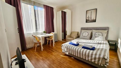 une chambre avec un lit, une table et un bureau dans l'établissement Studio Alba - 15min Paris RER E, cosy, à Noisy-le-Sec