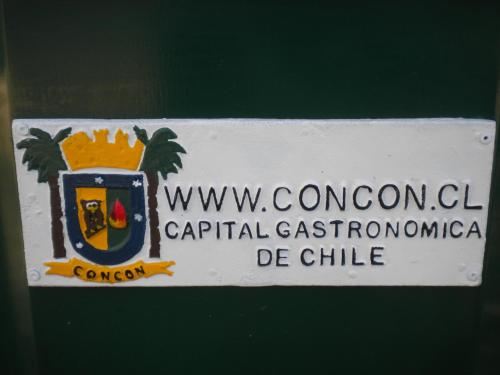 a white sign with a crest on the side of a building at Pacific Blue in Concón