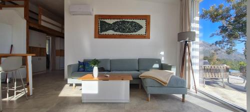 a living room with a blue couch and a table at Sunrise Lodge Dapčevići - Montenegro in Dapčevići