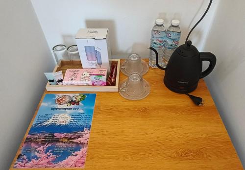 einen Tisch mit einem Wasserkocher und Büchern darüber in der Unterkunft Sirine​ Onsen​ รีสอร์ทออนเซนวิวทะเลหมอก in Khao Kho