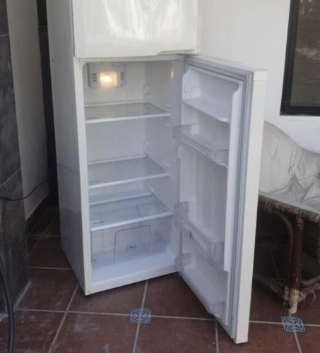 an empty refrigerator with its door open in a room at Casa con Alberca cerca del Aeropuerto in Torreón