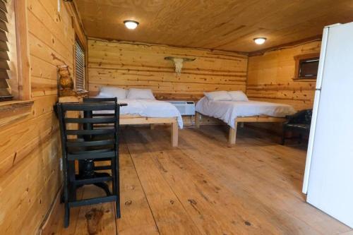 a room with two beds in a log cabin at Barn 1 Yellow Rose Canyon in Mount Enterprise
