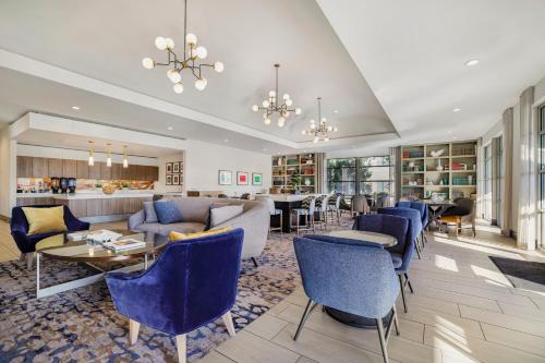 a living room with blue furniture and a bar at Homewood Suites by Hilton Plano-Richardson in Plano