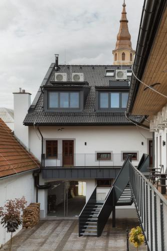 an external view of a white building with a staircase at Pension Zwolenčan in Zvolen