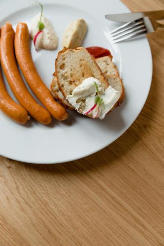 a plate of food with a sandwich and sausages at Pension Zwolenčan in Zvolen