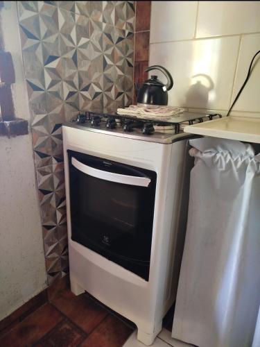 a kitchen with a stove with a tea kettle on it at L&M Housing Apartamentos y casa in Búzios
