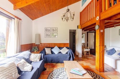 un salon avec un canapé bleu et une table dans l'établissement Lot Valley - hidden gem for peaceful getaways, à Tour-de-Faure