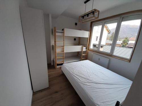 une petite chambre avec un lit et une fenêtre dans l'établissement Appartement familial 2 pièces, à Argelès-Gazost
