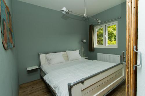 Bett in einem Zimmer mit Fenster in der Unterkunft Paardenstal, Private House with wifi and free parking for 1 car in Weesp