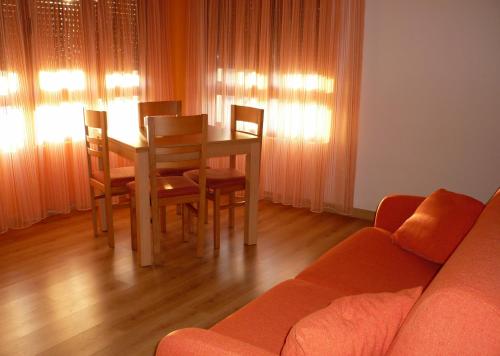 a living room with a table and chairs and a couch at Apartamentos Costa Costa in Suances