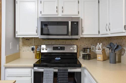 a kitchen with a stove and a microwave at Mountain Oasis Hot Tub Game Room Fire Pit in Pocono Summit