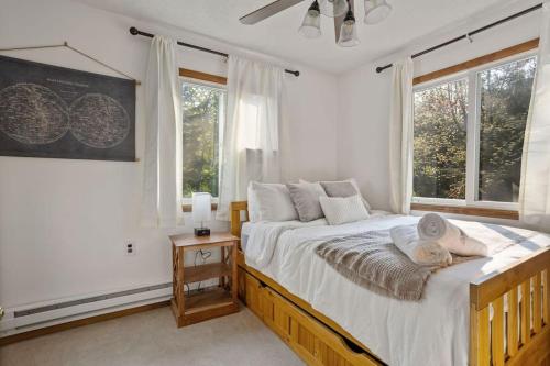 a bedroom with a large bed and two windows at Mountain Oasis Hot Tub Game Room Fire Pit in Pocono Summit