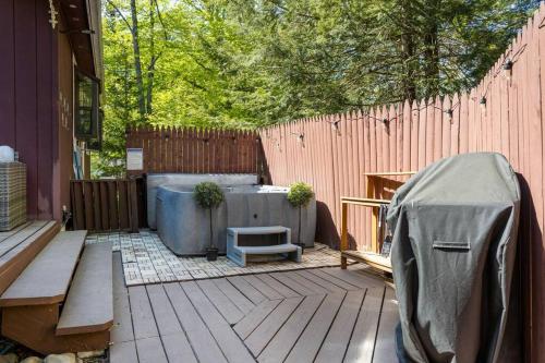 a patio with a fence and a bench and a hot tub at Mountain Oasis Hot Tub Game Room Fire Pit in Pocono Summit