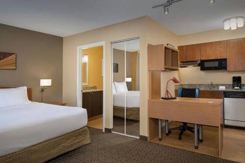 a hotel room with a bed and a desk and a kitchen at TownePlace Suites by Marriott Portland Hillsboro in Hillsboro