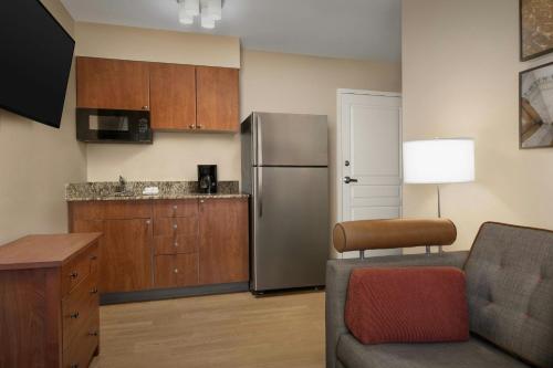 a kitchen with a stainless steel refrigerator and a couch at TownePlace Suites by Marriott Portland Hillsboro in Hillsboro