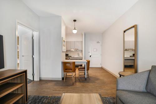 a living room with a table and a kitchen at Homewood Suites by Hilton Plano-Richardson in Plano
