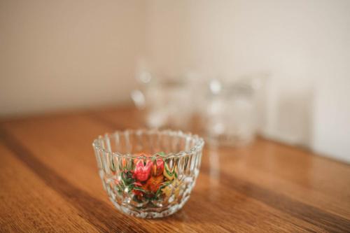 a glass bowl with flowers on a wooden table at B&B Passage in Sremska Mitrovica
