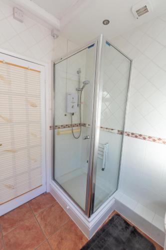 a shower in a bathroom with a glass shower stall at The Marion Plas in Prestatyn