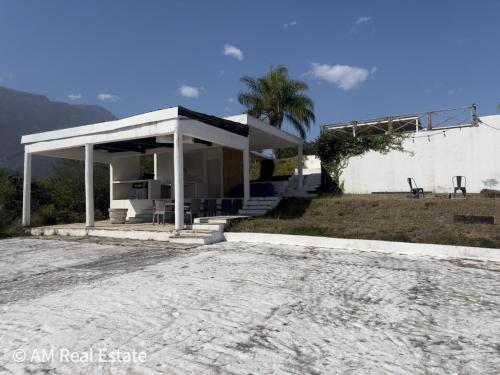 a white house with a porch and a driveway at Villa Santorini - Quinta con alberca en el barrial Santiago NL in Santiago