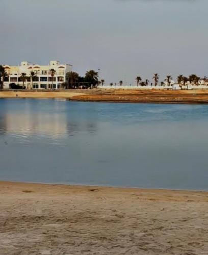 a body of water next to a beach with houses at درة العروس - شاطيء الحالمة - شاطيء صالح للسباحة - شاليه فاخر in Durat  Alarous