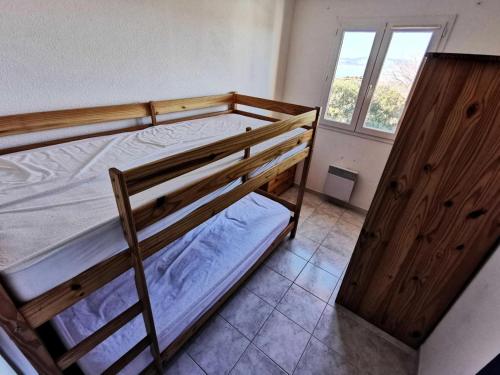 une chambre avec deux lits superposés et une fenêtre dans l'établissement Résidence Les Bastides Du Cap - Villa 4 pièces - 6 couchages LE BARCARES MAE-8421, au Barcarès