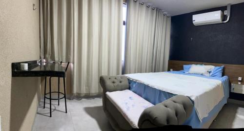 a bedroom with a large bed and a table at Apto 112 CENTRO in Araguaína