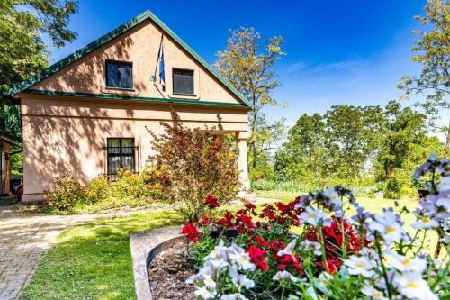 a house with flowers in front of it at Secluded family friendly house Draz, Baranja - 15893 in Draž